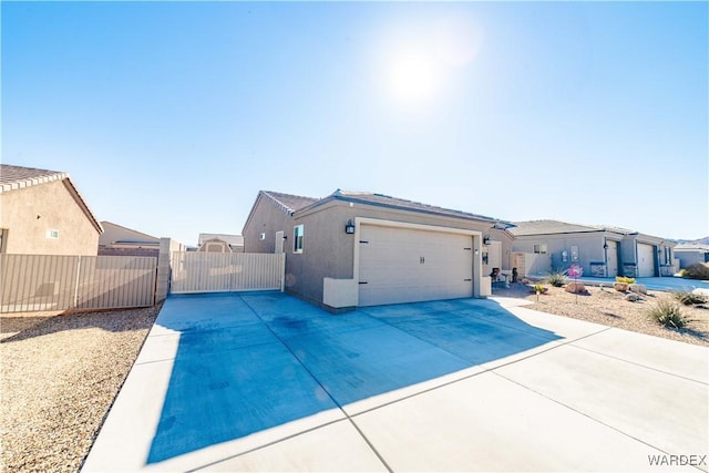 exterior space with driveway, a gate, fence, and stucco siding