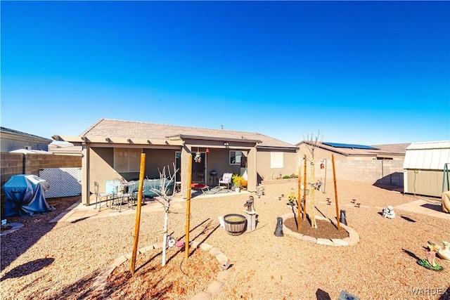 back of property featuring a patio, an outdoor structure, a fenced backyard, and stucco siding