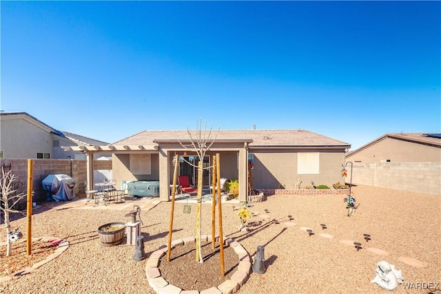 back of property with a fenced backyard, a patio, and stucco siding