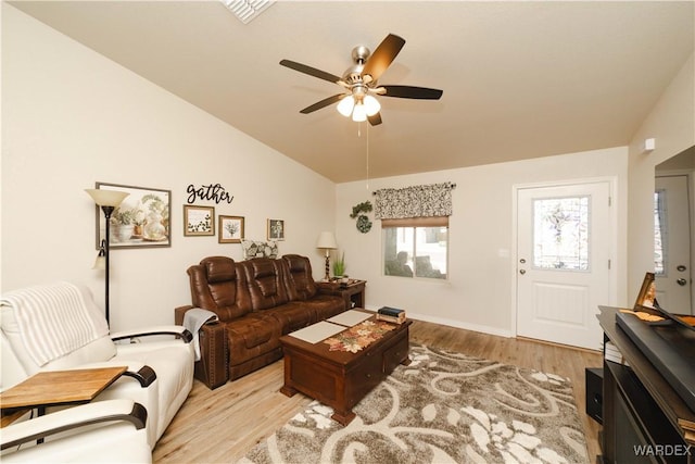 living room with vaulted ceiling, visible vents, light wood-style flooring, and a ceiling fan