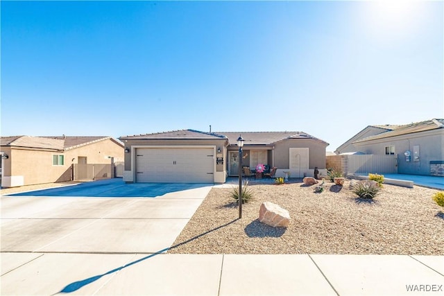 ranch-style home with driveway, an attached garage, fence, and stucco siding