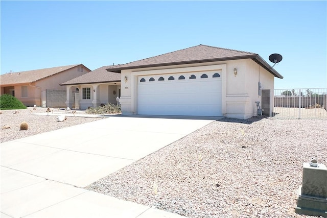 ranch-style home with fence, an attached garage, driveway, and stucco siding