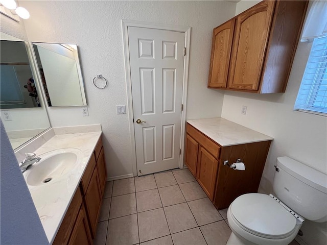 bathroom featuring toilet, vanity, and tile patterned floors