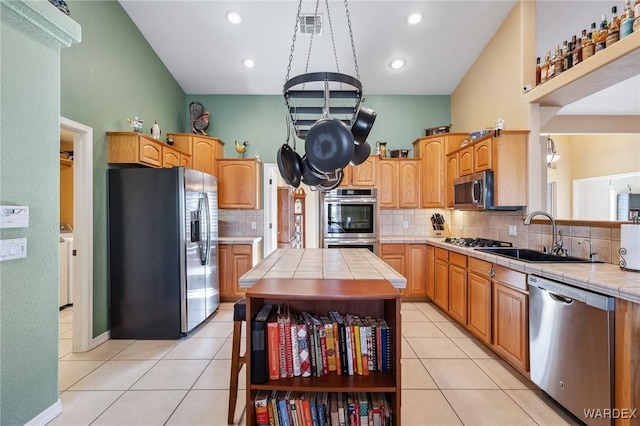 kitchen featuring tile countertops, light tile patterned floors, stainless steel appliances, visible vents, and a sink