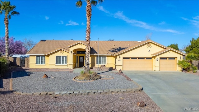 ranch-style home with a garage, stucco siding, driveway, and a tiled roof