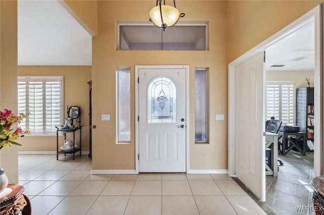 foyer featuring a wealth of natural light, baseboards, and light tile patterned floors