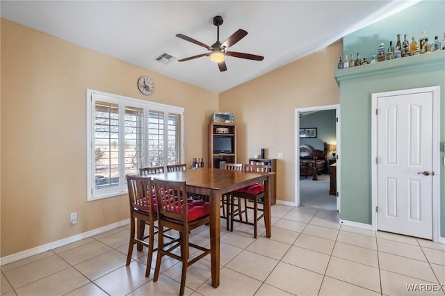 dining room with lofted ceiling, visible vents, a ceiling fan, light tile patterned flooring, and baseboards