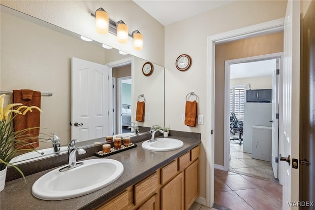 ensuite bathroom featuring double vanity, a sink, and connected bathroom