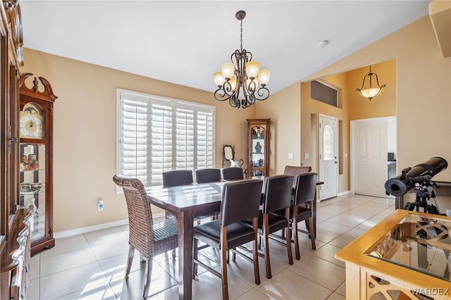 dining space featuring lofted ceiling, light tile patterned floors, baseboards, and an inviting chandelier