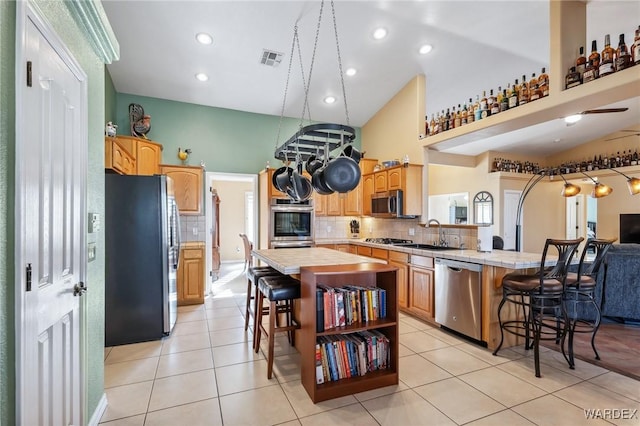 kitchen with stainless steel appliances, a breakfast bar, a peninsula, and visible vents