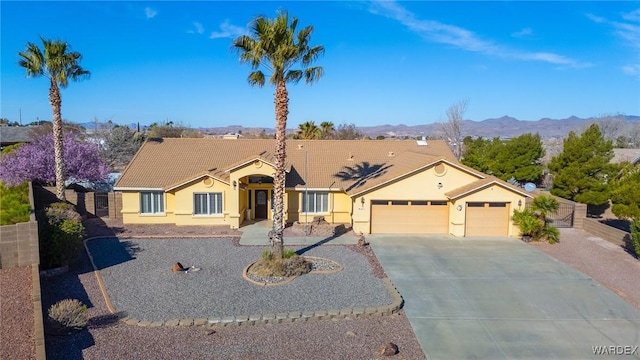 ranch-style home featuring stucco siding, concrete driveway, fence, a garage, and a tiled roof