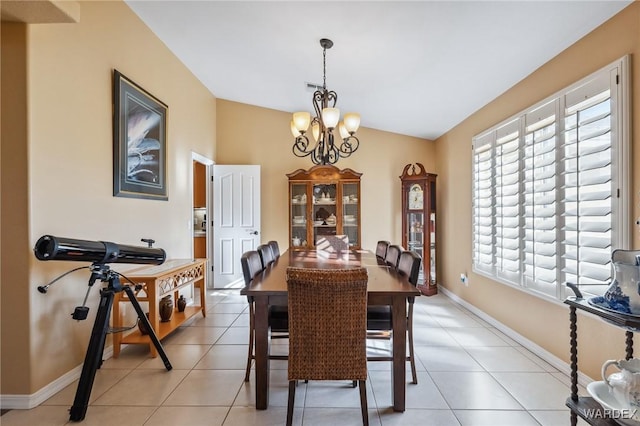 dining area featuring baseboards, a chandelier, vaulted ceiling, and light tile patterned flooring