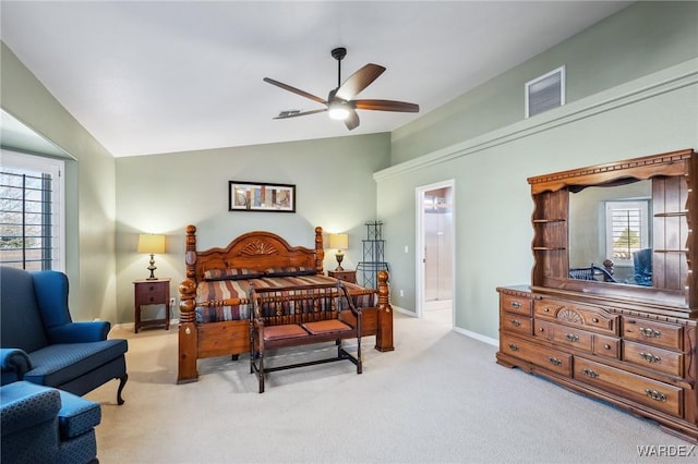 carpeted bedroom featuring lofted ceiling, visible vents, and baseboards