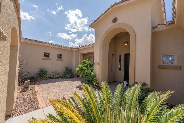 doorway to property with a patio and stucco siding