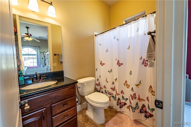 bathroom with a shower with curtain, toilet, ceiling fan, vanity, and tile patterned flooring