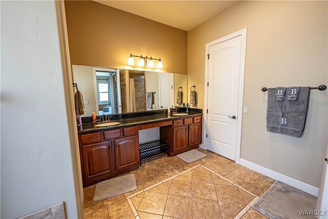 full bathroom with double vanity, baseboards, a sink, and tile patterned floors