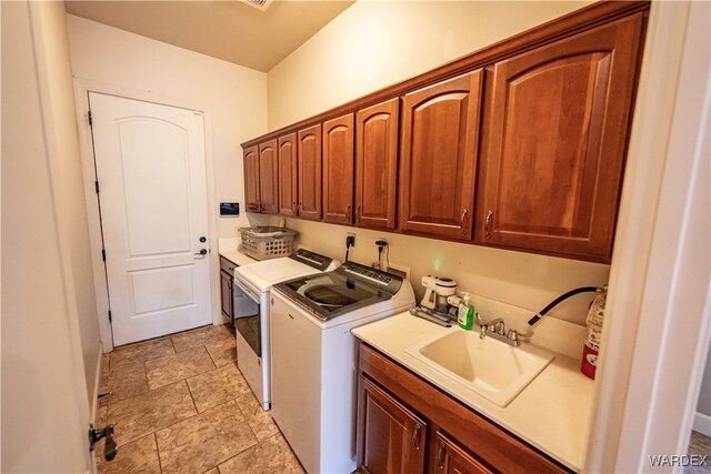 laundry area featuring washing machine and dryer, a sink, and cabinet space