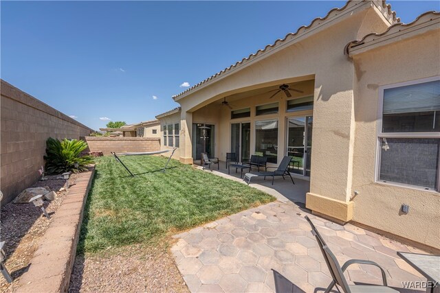 view of yard featuring a patio, outdoor lounge area, a fenced backyard, and a ceiling fan