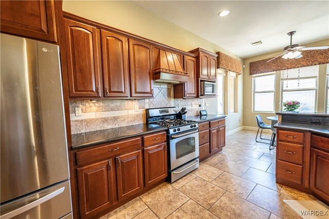 kitchen featuring stainless steel appliances, visible vents, a ceiling fan, backsplash, and dark countertops