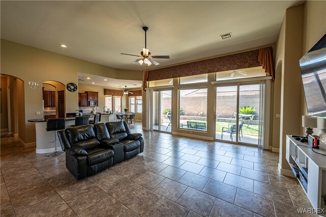 living room with visible vents, arched walkways, baseboards, ceiling fan, and recessed lighting