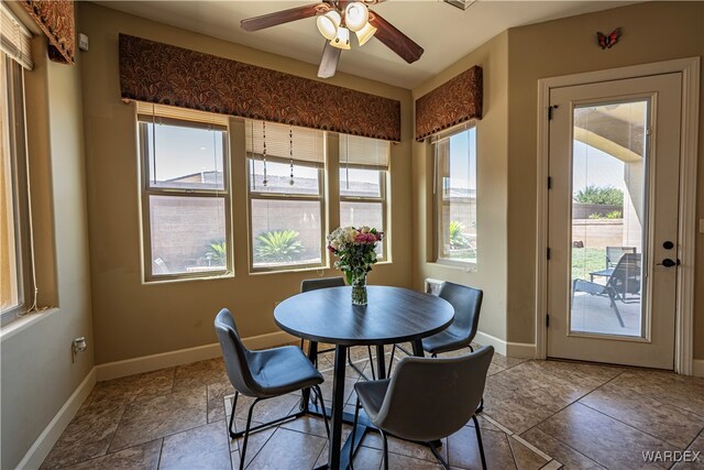 dining area with a ceiling fan and baseboards