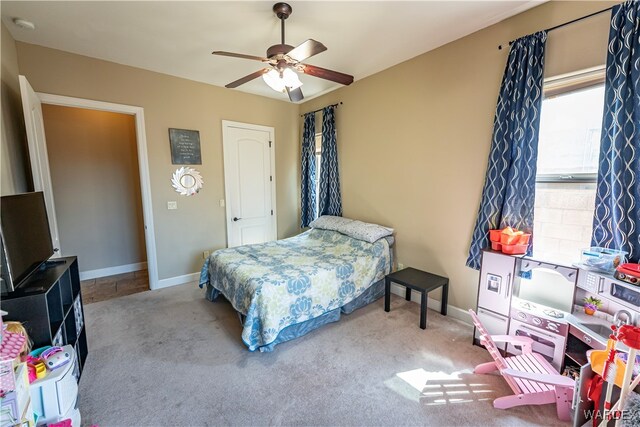 bedroom featuring light carpet, ceiling fan, and baseboards