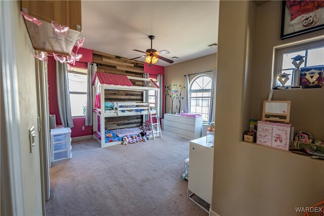 bedroom with carpet floors, visible vents, and wooden walls