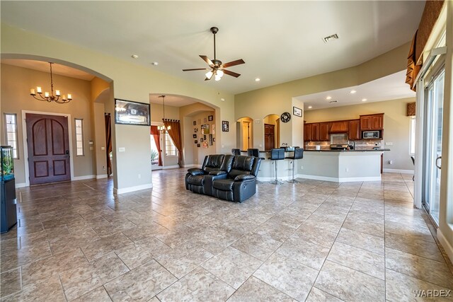 living area with recessed lighting, baseboards, visible vents, stairway, and ceiling fan with notable chandelier