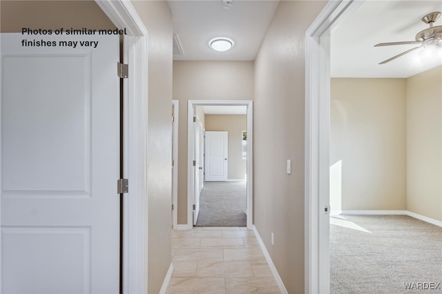 hall with baseboards, light carpet, and marble finish floor