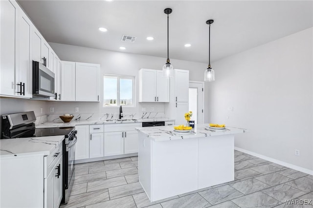 kitchen with appliances with stainless steel finishes, a kitchen island, white cabinets, a sink, and visible vents