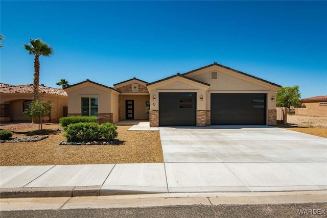 view of front facade featuring concrete driveway, stone siding, an attached garage, and stucco siding