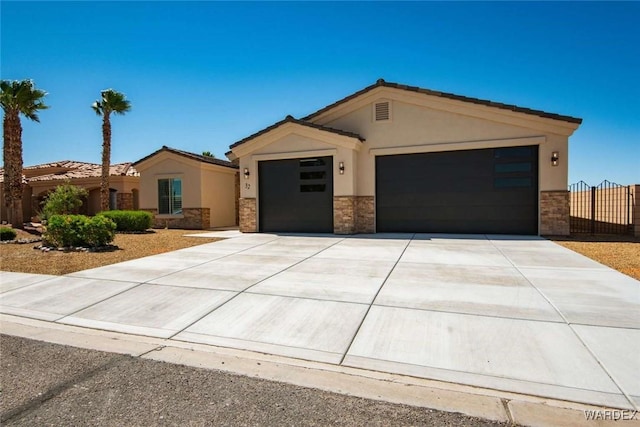 view of front of house with stone siding, an attached garage, driveway, and stucco siding