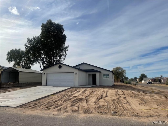 ranch-style home featuring a garage, driveway, and stucco siding