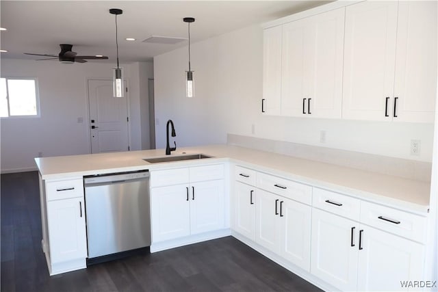 kitchen featuring a peninsula, light countertops, stainless steel dishwasher, white cabinetry, and a sink