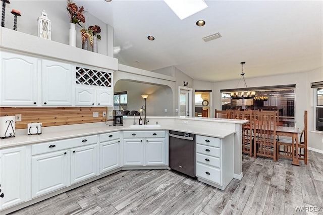 kitchen with dishwashing machine, white cabinets, a sink, and light countertops