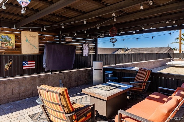 view of patio with an outdoor fire pit and fence