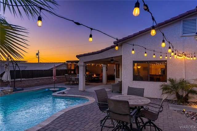 view of pool featuring a fenced in pool, ceiling fan, fence, a patio area, and outdoor dining space