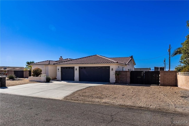 view of front of home featuring an attached garage, fence, a tiled roof, concrete driveway, and stucco siding