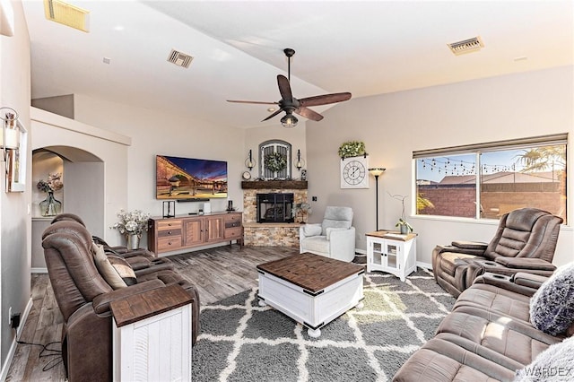 living room featuring visible vents, a fireplace, and arched walkways