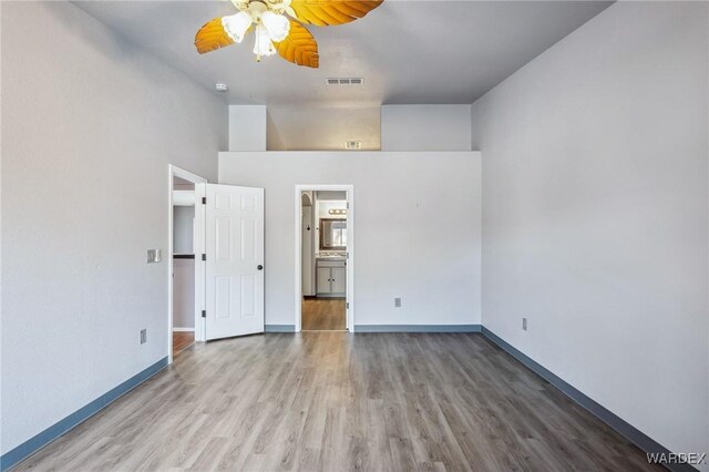 unfurnished bedroom with visible vents, baseboards, and wood finished floors