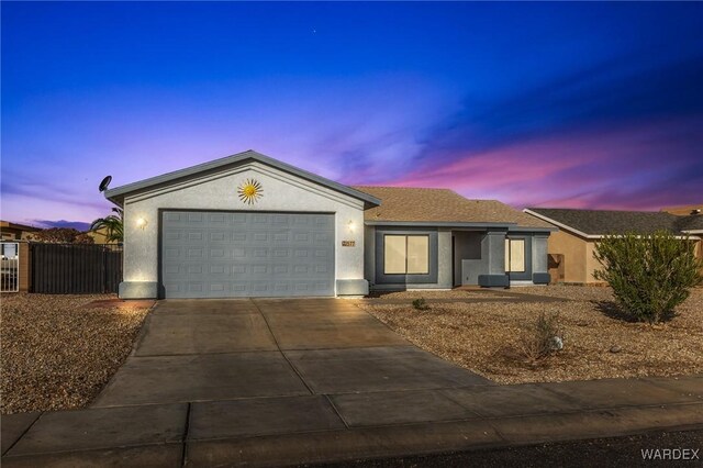 ranch-style house featuring concrete driveway, an attached garage, fence, and stucco siding