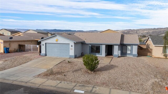 ranch-style house featuring a mountain view, a garage, driveway, a residential view, and stucco siding