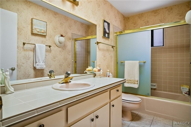 full bathroom featuring toilet, bath / shower combo with glass door, vanity, tile patterned floors, and wallpapered walls