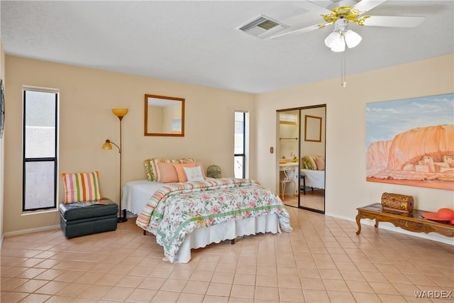 bedroom featuring ceiling fan, multiple windows, visible vents, and light tile patterned flooring