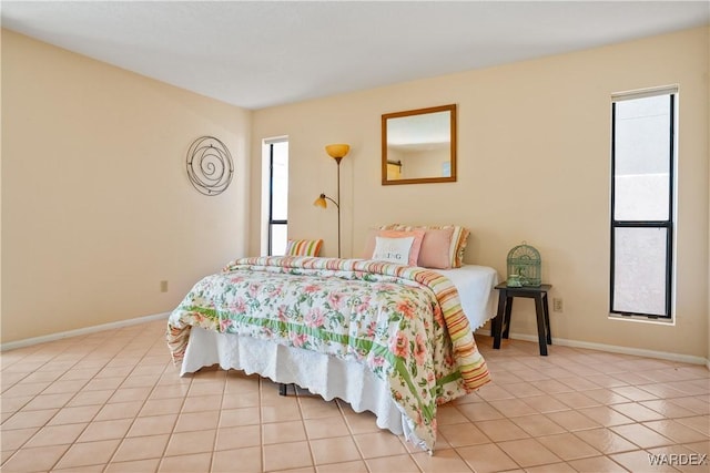 bedroom with baseboards and light tile patterned floors