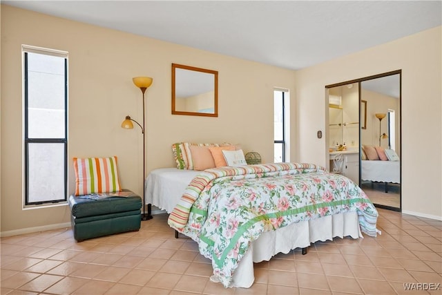 bedroom featuring light tile patterned floors, multiple windows, and baseboards