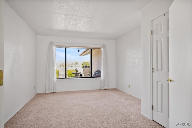 carpeted spare room with a textured ceiling