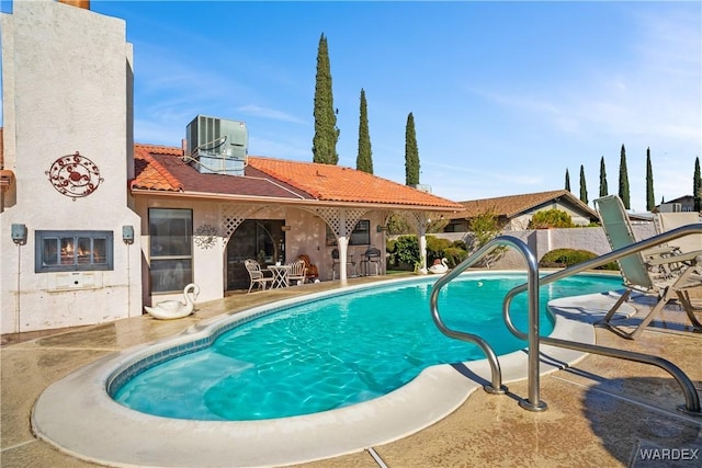 view of pool with a patio area, fence, central AC unit, and a fenced in pool