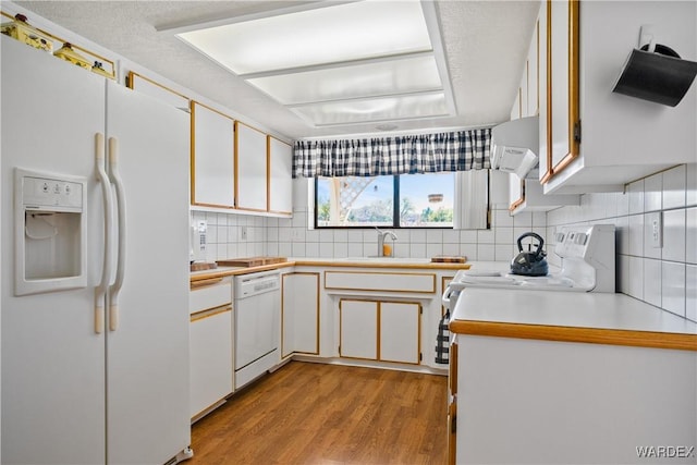 kitchen featuring light countertops, white appliances, light wood-type flooring, and decorative backsplash