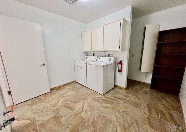 laundry room featuring visible vents, washing machine and clothes dryer, and cabinet space